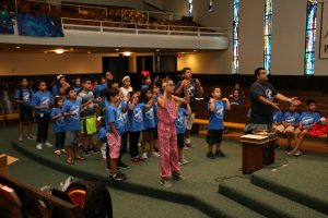 David Flores leads the children as they dance along with the interactive video being shown on the last day of Vacation Bible School on 3 August, 2017.