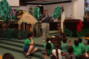 Pastor Alfonso Flores speaks to the children from the pulpit at Vacation Bible School on July 30, 2015.