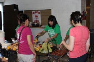 Volunteers serve food to the parents and children in the gym at Vacation Bible School on July 30, 2015.