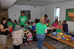 Children and parents enjoy tasty hotdogs and other food in the gym at Vacation Bible School on July 30, 2015.