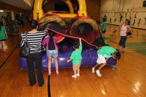 Children exit  an inflatable obstacle challenge course in the gym at Vacation Bible School on July 30, 2015. 